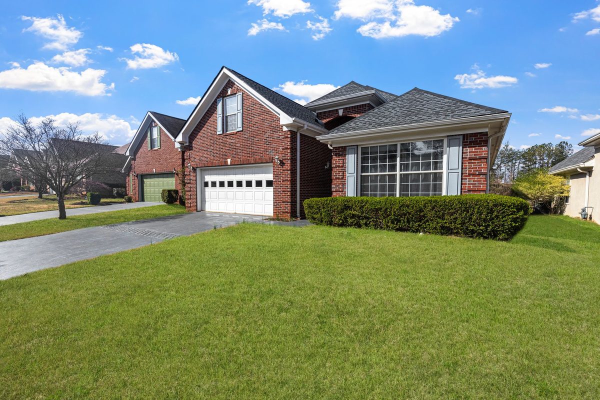 Red brick suburban home with a white two-car garage door